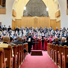 Photo of a large chamber choir performing in a church