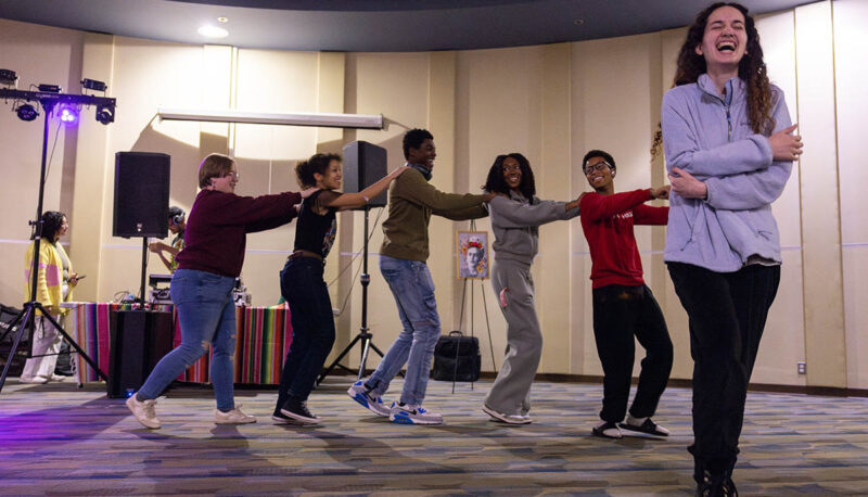 Students dancing in a conga line.