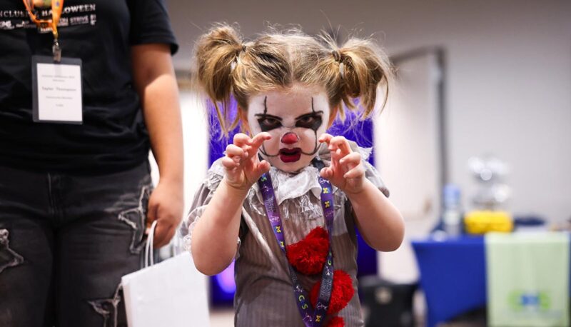 A small child dressed up like a scary clown