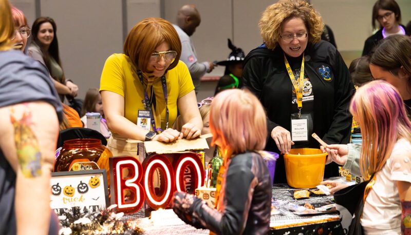 A table of UM-Flint volunteers with trick or treaters