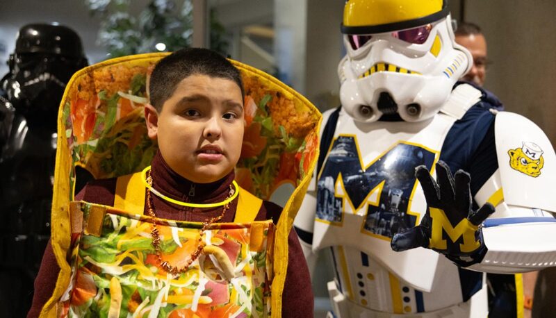 A child in a taco costume posing with the Wolverine Stormtrooper.