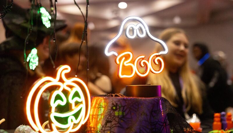 Neon Halloween signs hanging from a table