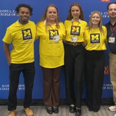 UM-Flint School of Management Marketing Students and Professor Dan Lake pose for a photo in front of the Saginaw Valley State University Regional Sales Competition banner on Oct. 12.