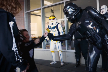 A crew of Star Wars stormtroopers giving out treats to a child attending Inclusive Halloween