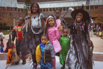 A group of young trick or treaters dressed up in costumes in McKinnon Plaza