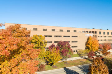 An aerial photograph of the Muchie Science Building and autumn leaves on Kearsley St.