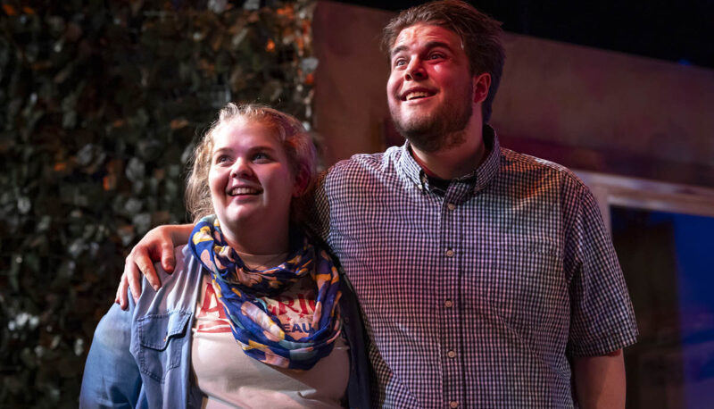 Two student actors standing arm-in-arm