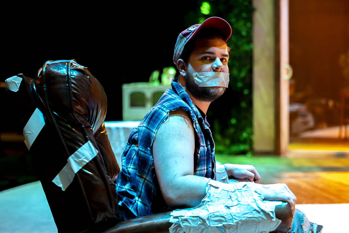 A student actor on stage duct taped to a chair