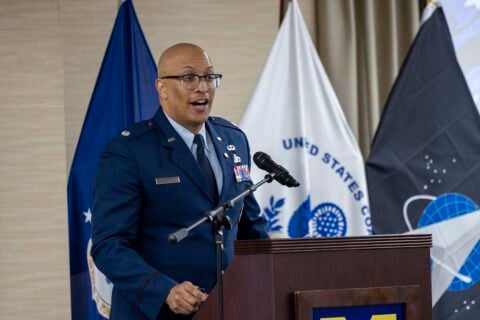 A man in an Air Force dress uniform speaking at a podium.