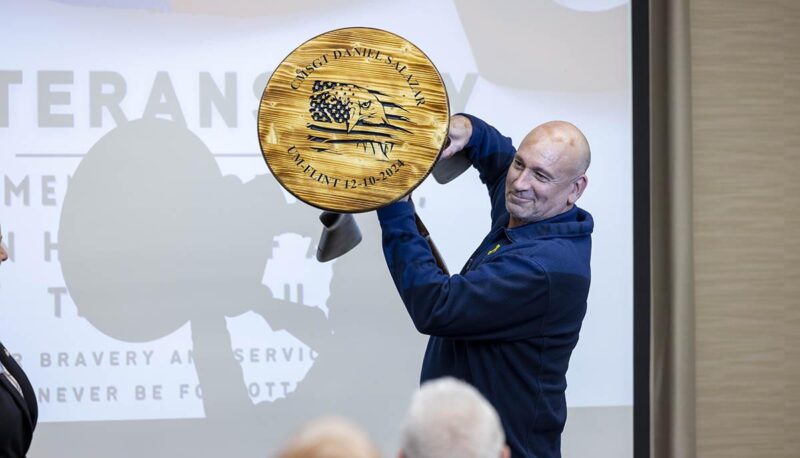 Daniel Salazar showing off a woodburning piece of art.