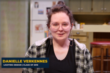 A screenshot of Danielle Verkennes sitting on stage talking to the camera.