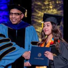 Chancellor Alexander shakes hands with a UM-Flint graduate