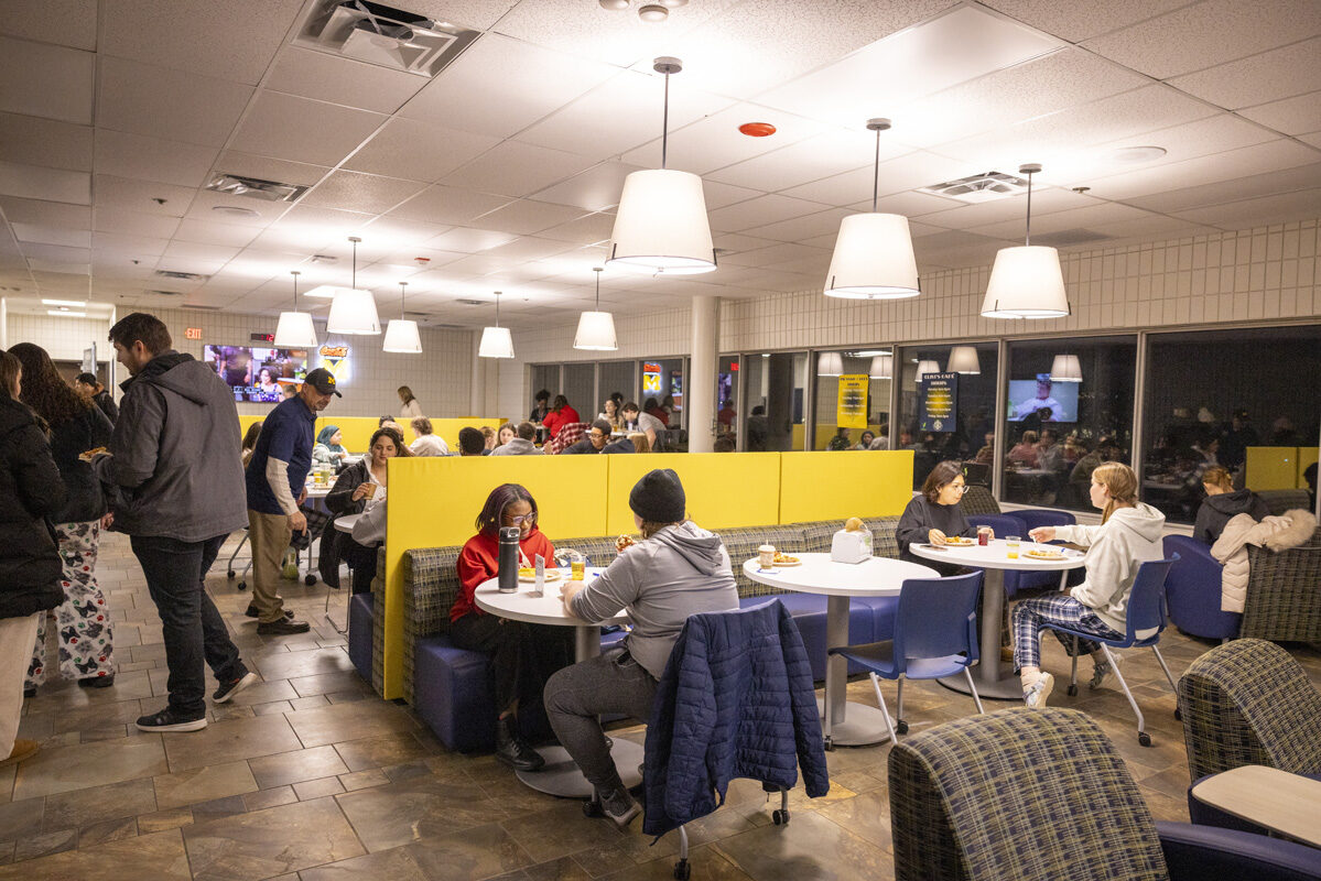 A dining area with people seated at booths and tables, eating and socializing.