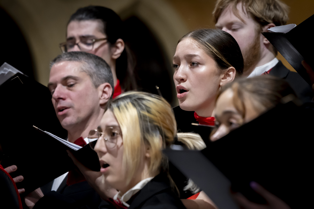 A group of singers performs while holding sheet music.