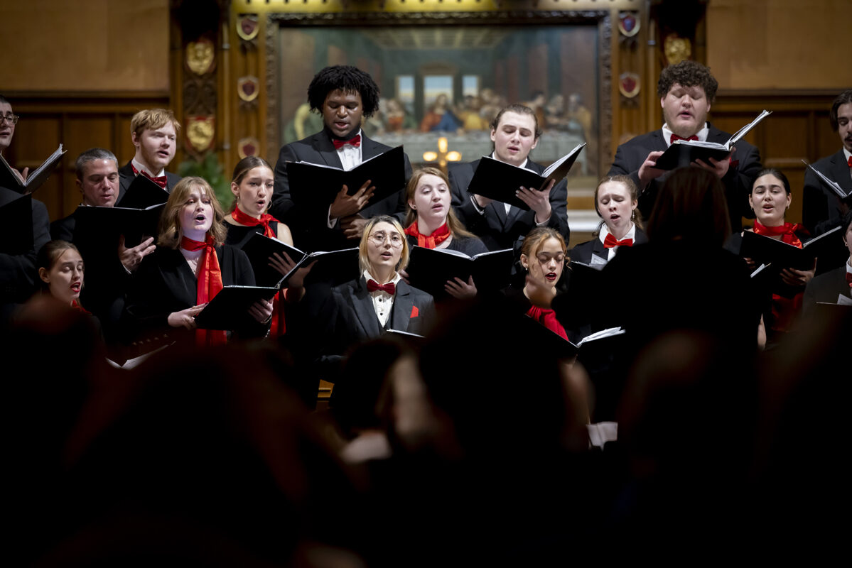 A choir performs with a conductor in a grand church setting.