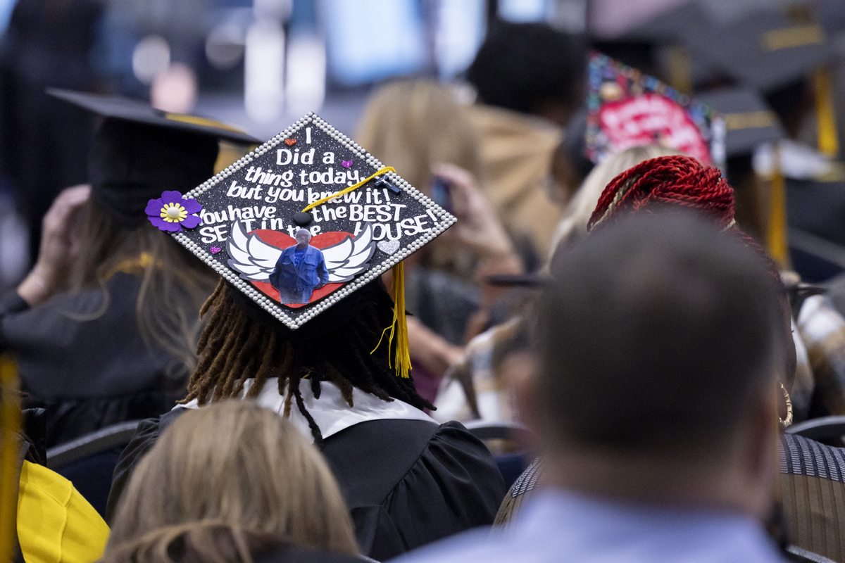 A graduation cap decorated with a heart, angel wings, and a message about having the "best seat in the house."