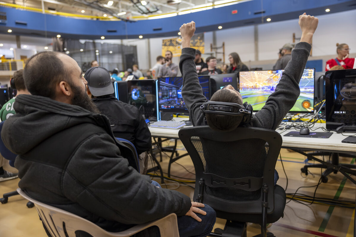 A player raises their arms in celebration during a gaming session.