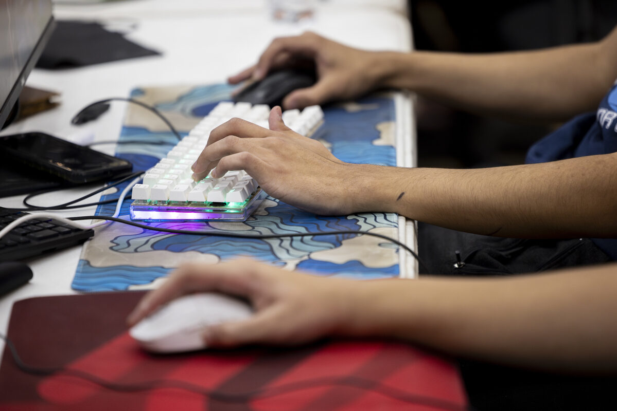 Close-up of hands on a gaming keyboard and mouse.