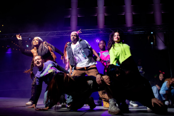 A group of dance performers on stage during an outdoor arts festival in Flint, MI