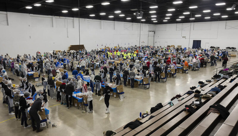 A wide shot of a crowd UM-Flint volunteers packing food