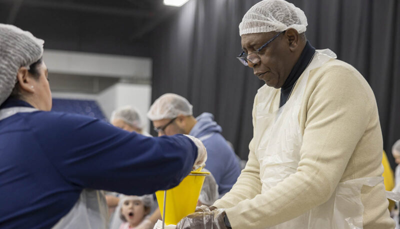 UM-Flint volunteers in hairnets packing food