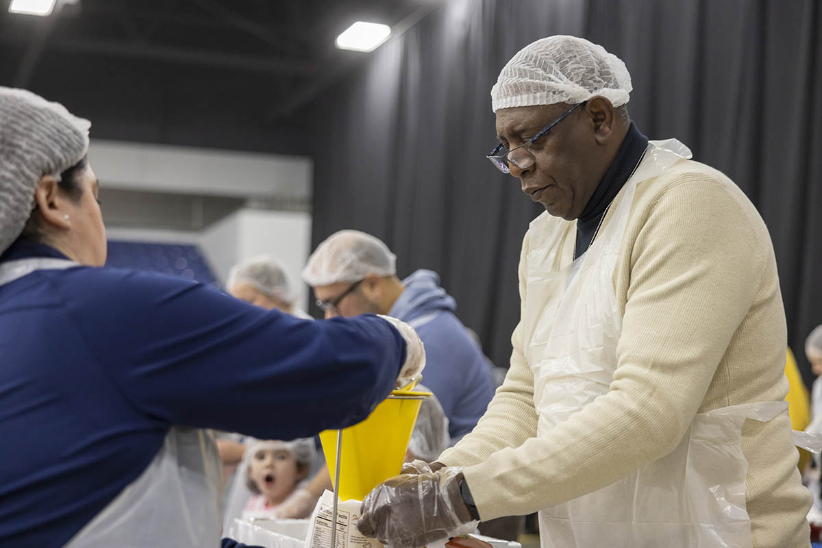 UM-Flint volunteers in hairnets packing food