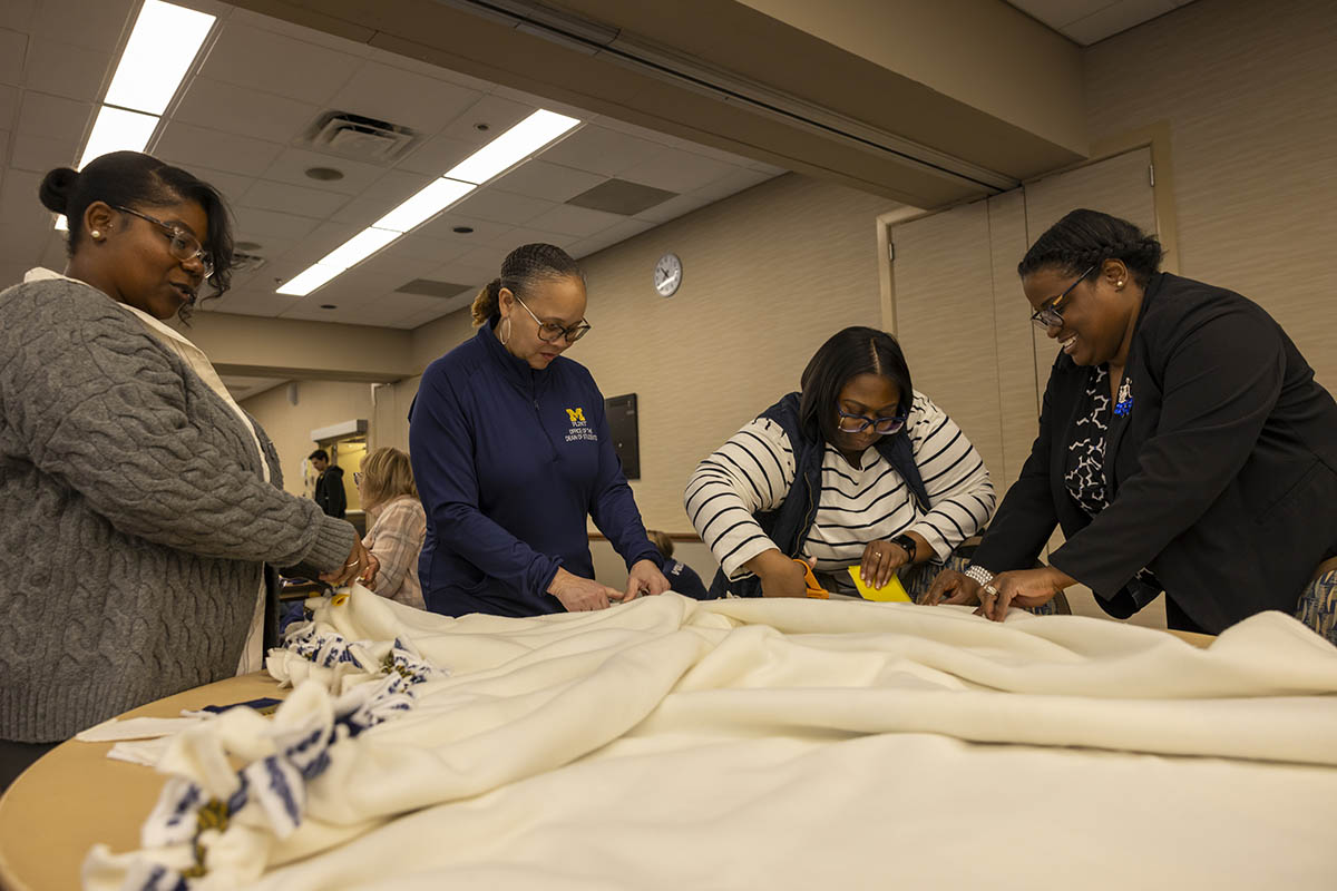 A group of UM-Flint volunteers working on a blanket