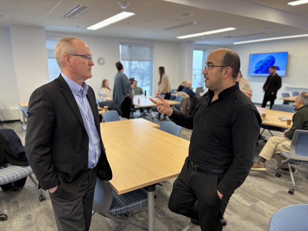 Principal investigators Ken Sylvester (left) and Mohamed Wiem Mkaouer discussed the implications of new NSF funding at a faculty meeting on the UM-Flint campus, Jan. 10.