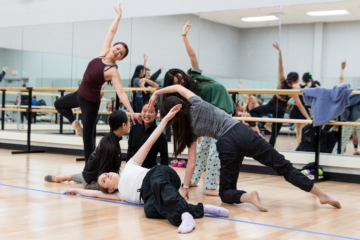 A group of dancers performing in a dance studio