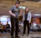 An occupational therapy patient getting ready to throw a bowling ball down the lane at an alley while an OT student stands behind him.