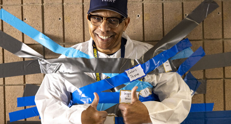 Chancellor Alexander giving a thumbs up while being duct taped.