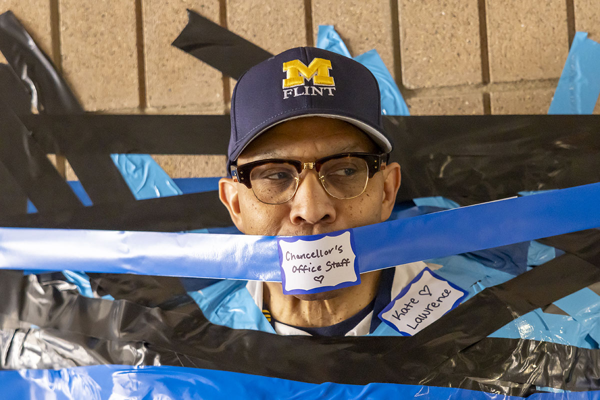 A close up of Chancellor Alexander with duct tape over his mouth