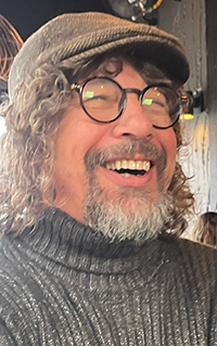 A portrait of a man smiling at the camera