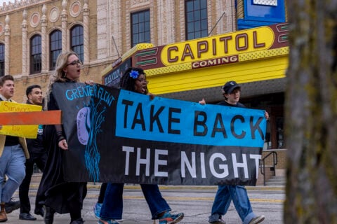 Marchers holding the Take Back the Night banner in front of the Capitol Theatre