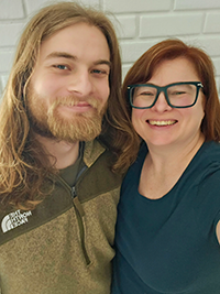 A mother and son smiling at the camera