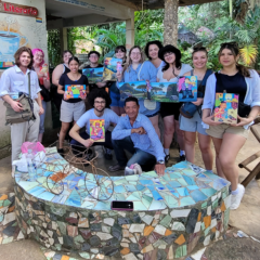 A group of students holding art and posing for the camera in Havana Cuba