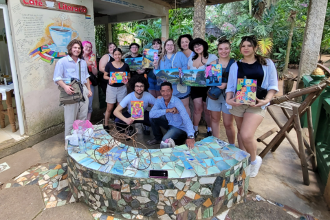 A group of students holding art and posing for the camera in Havana Cuba