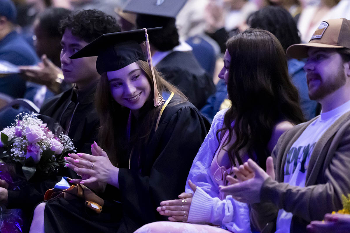 A closeup of a family and graduating student in the crowd.