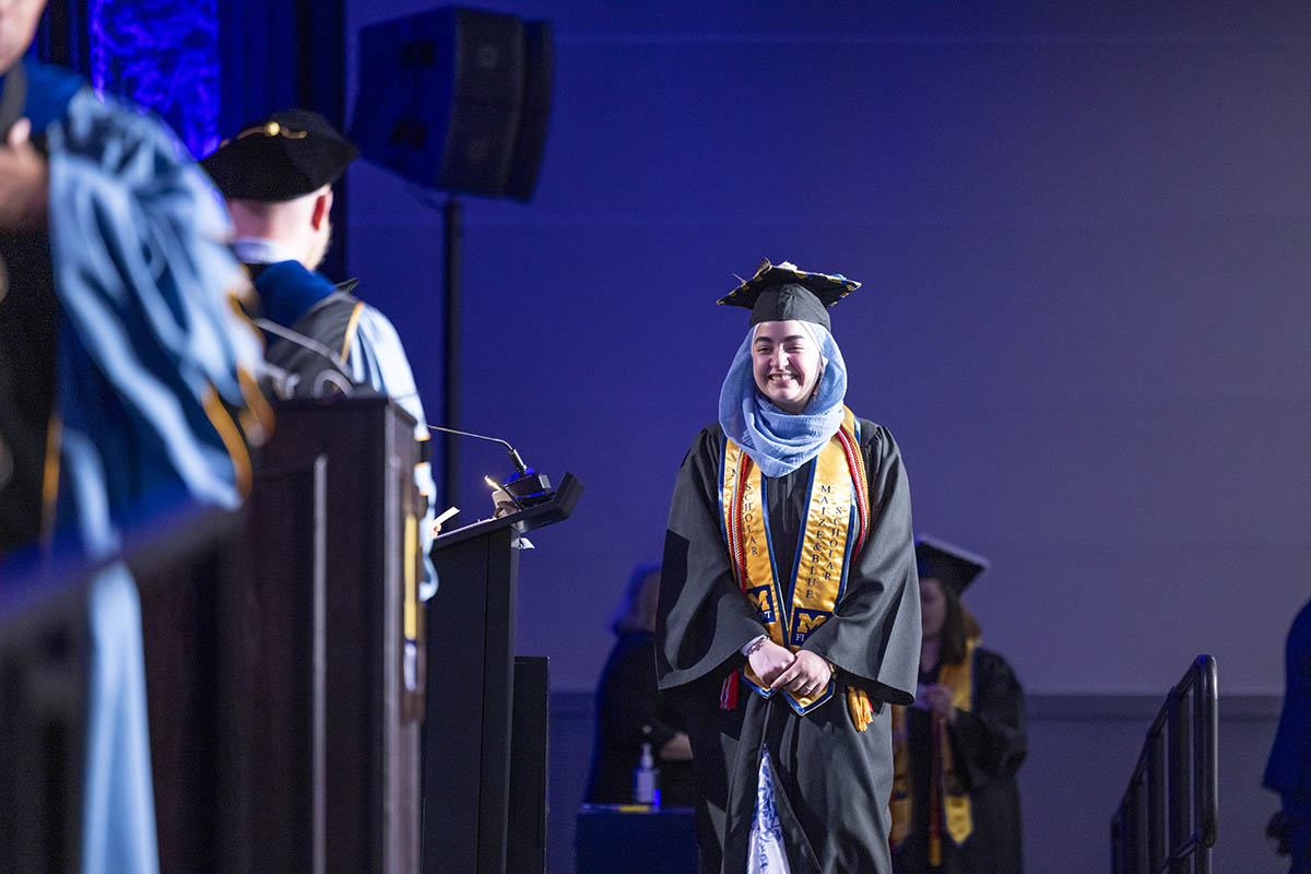 A student walking across the stage.
