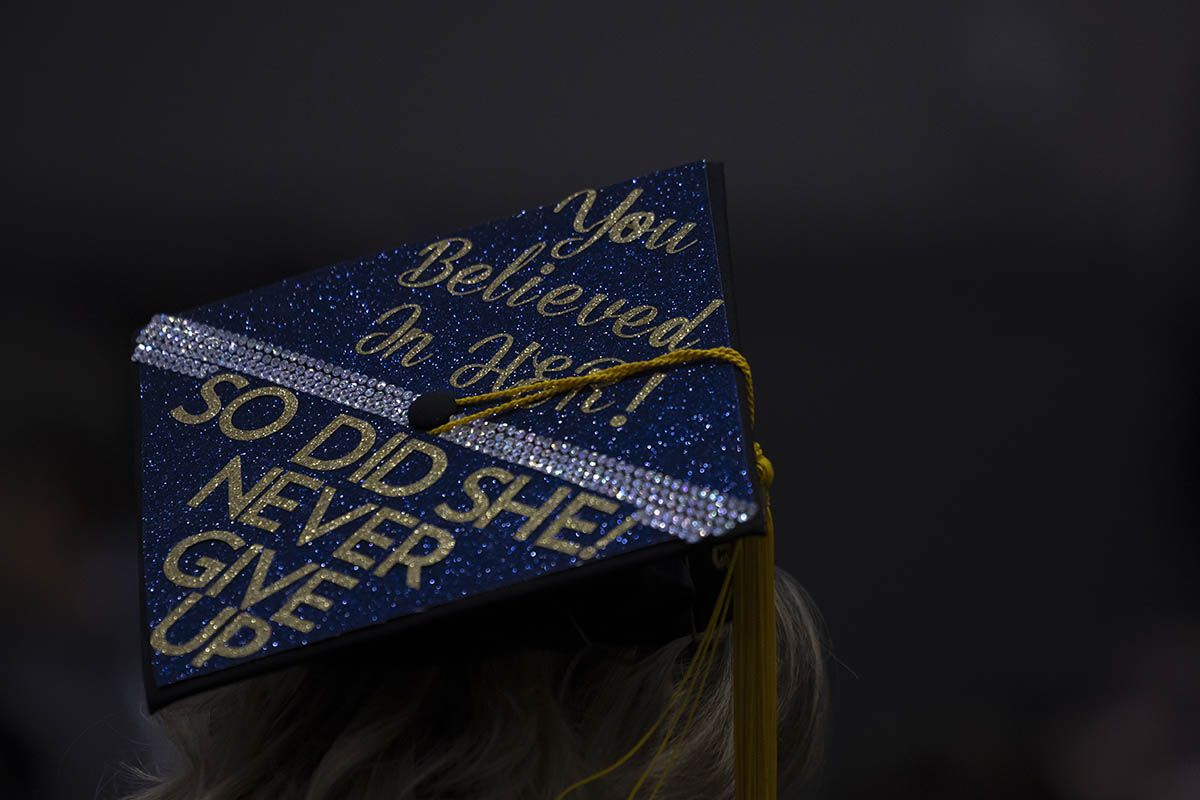 A decorated graduation cap that says "You believed in her, so did she! Never give up."