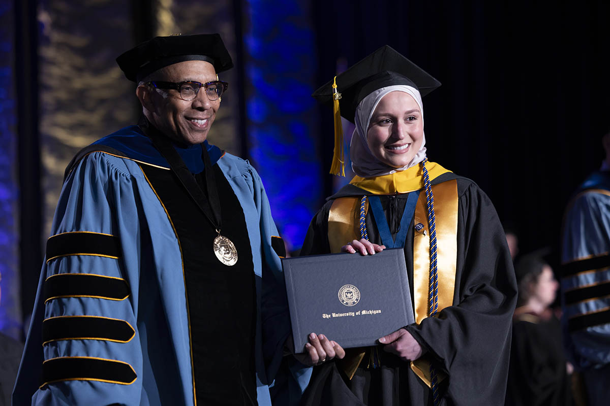 A student shaking hands with Chancellor Alexander receiving her diploma on stage.