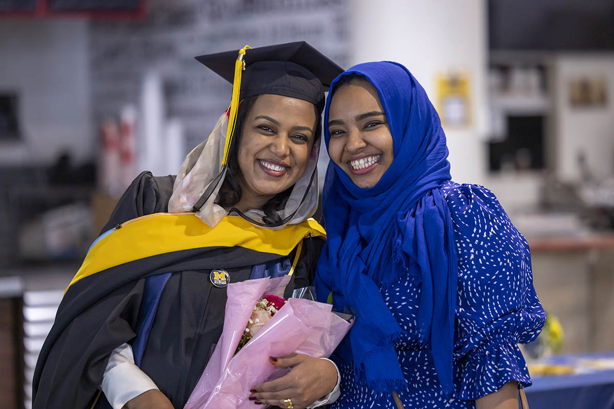A graduating student with a family member in the University Pavilion