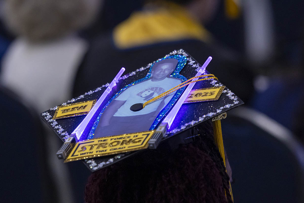 A decorated graduation cap that says "The force is strong with this one." It also appears to feature a photo of the graduate's father.