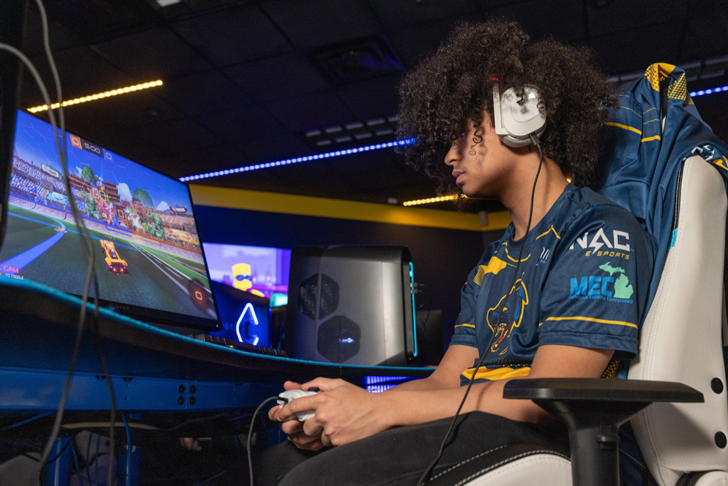 A man sitting at a computer desk playing a video game. 