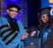 A student receiving her diploma on stage from Chancellor Laurence Alexander