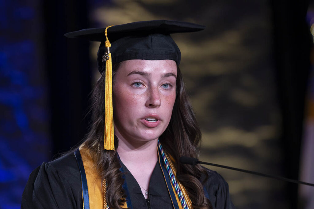 Lani Manners speaking on stage. The photo is from the shoulders up.