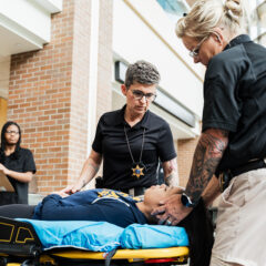 Police officers treating the mock patient on the stretcher.