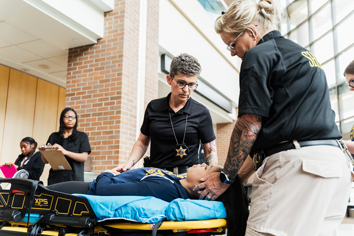 Police officers treating the mock patient on the stretcher.