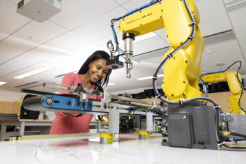 A student works on a robotic arm.
