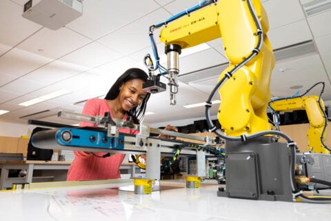 A student works on a robotic arm.